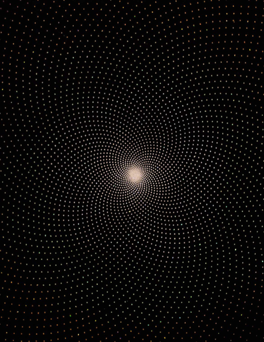Spiral of dots radiating from a glowing centre on black